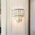 Modern silver crystal tiered wall mounted wall light with sleek metal frame and cascading faceted crystals emitting warm light