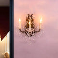 Antique-style crystal chandelier with three candle-like bulbs and ornate metalwork as modern teardrop wall lamp for living room