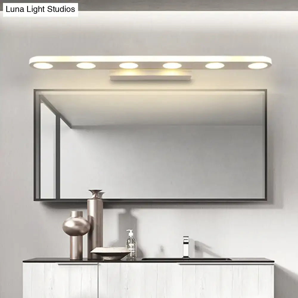 Modern rectangular bathroom mirror with a sleek black frame illuminated by a white 3-light vanity wall light with warm white light
