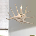 Modern white antler resin shade wall sconce featuring a single lit candle-style bulb for living room light