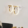 Modern white and gold ring light fixture with two glowing circular rings as a sleek wall light for living rooms