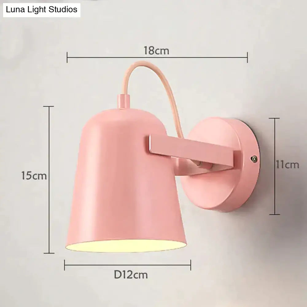 Pastel pink conical matte ferrell wall lamp with curved arm designed as a modern adjustable bedroom spotlight
