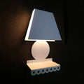 Modern white metal trapezoid wall sconce with tapered shade and scalloped base for bedroom lighting