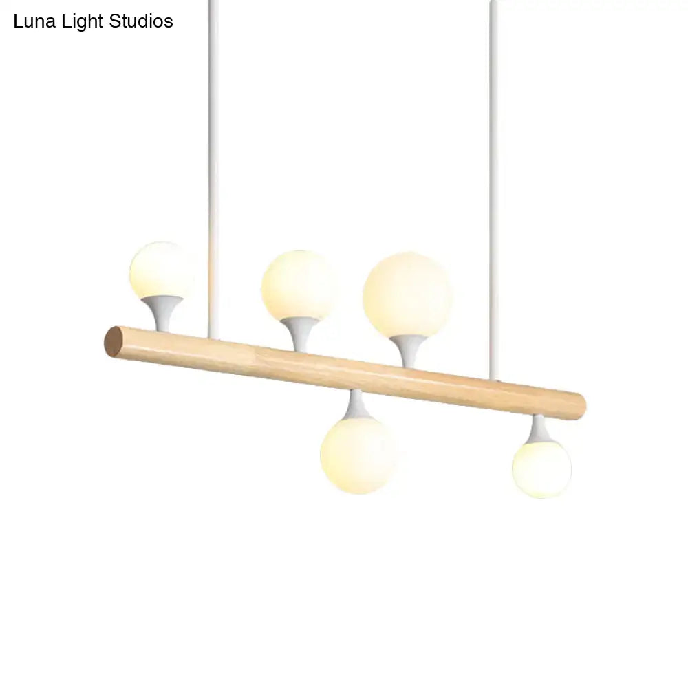 Modern white pipe island dining room pendant light with natural wood bar and four frosted glass globe bulbs