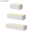Set of three modern white rectangular wall lamps with warm white diffused lighting and textured top surface for bedrooms