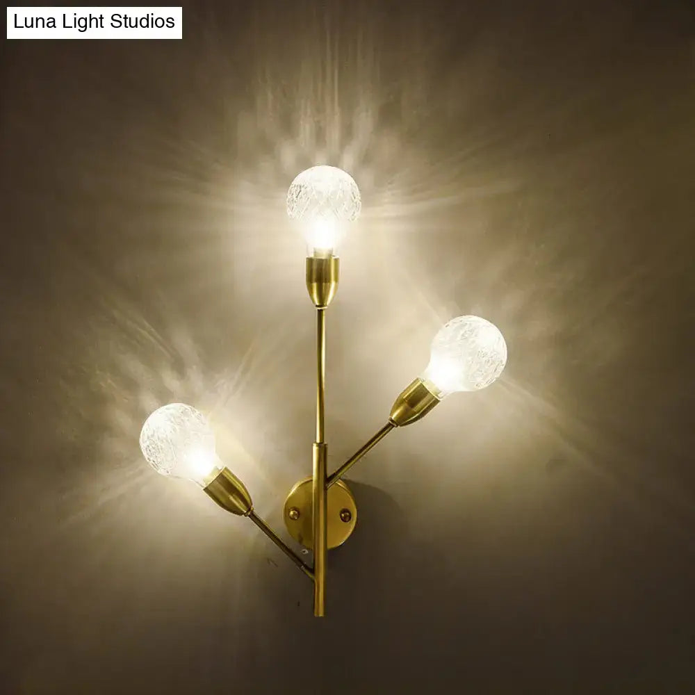 Modernist brass wall mount light fixture with prismatic glass bedroom
