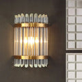 Modernist clear crystal wall sconce with gold finish and vertical glass tubes for elegant living room lighting