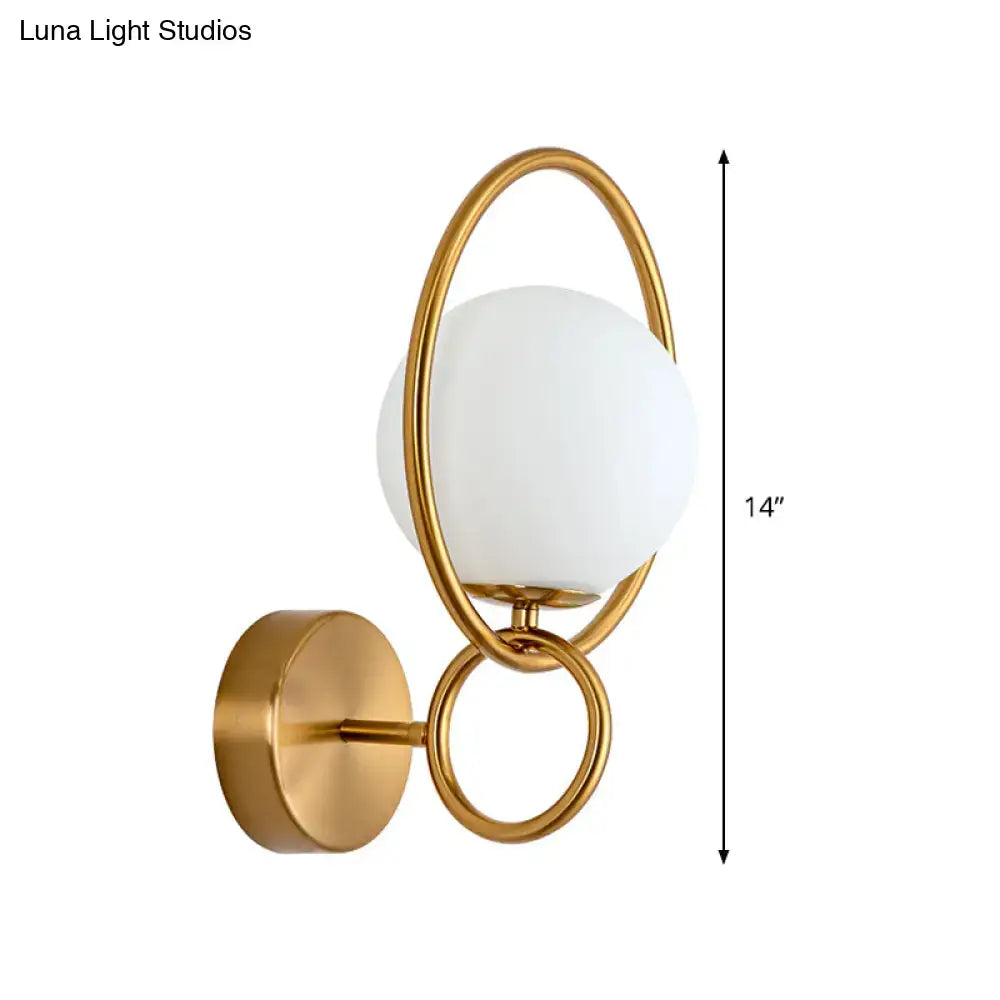 Modernist gold wall sconce with white glass shade for bedroom