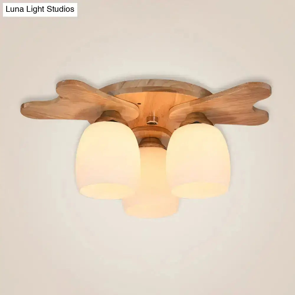 Nordic cream glass bell ceiling light featuring three warm-toned cream glass shades and wooden leaf-shaped arms