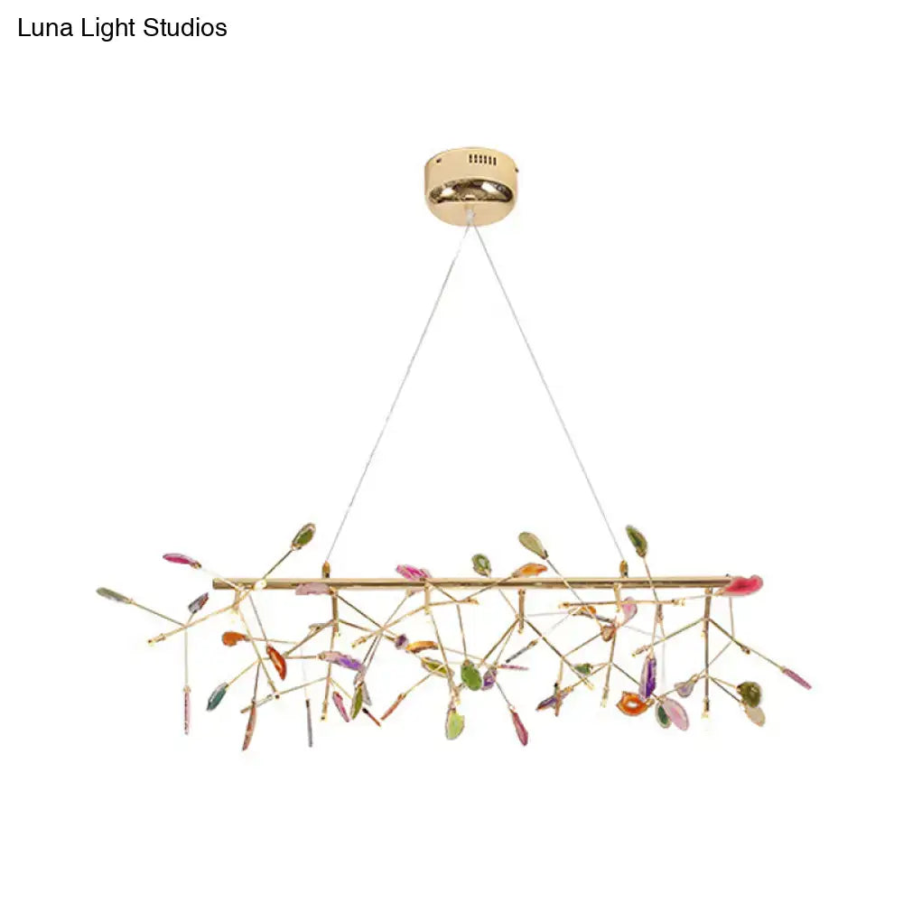 A modern gold-toned pendant ceiling light with colorful glass leaves for dining room light type and decor