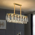 Gold-toned DecorBites™ minimalist crystal leaf pendant light with clear crystal teardrops and ornate fixture width design
