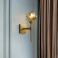 Post modern brass wall light sconce with gold-toned finish and textured frosted amber glass globe for living room use