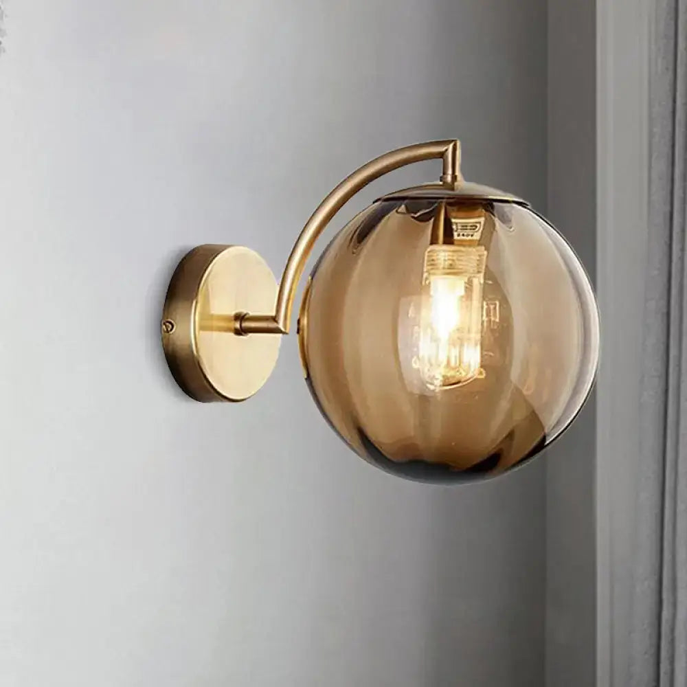 Postmodern brass armed ball sconce – bedroom amber glass wall light