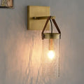 Postmodern brass wall sconce with clear crack glass cylinder and leather strap accents for dining room lighting