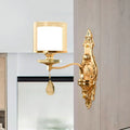 Gold-finished ornate wall mount lamp with frosted glass shade and teardrop crystal pendant for living room use