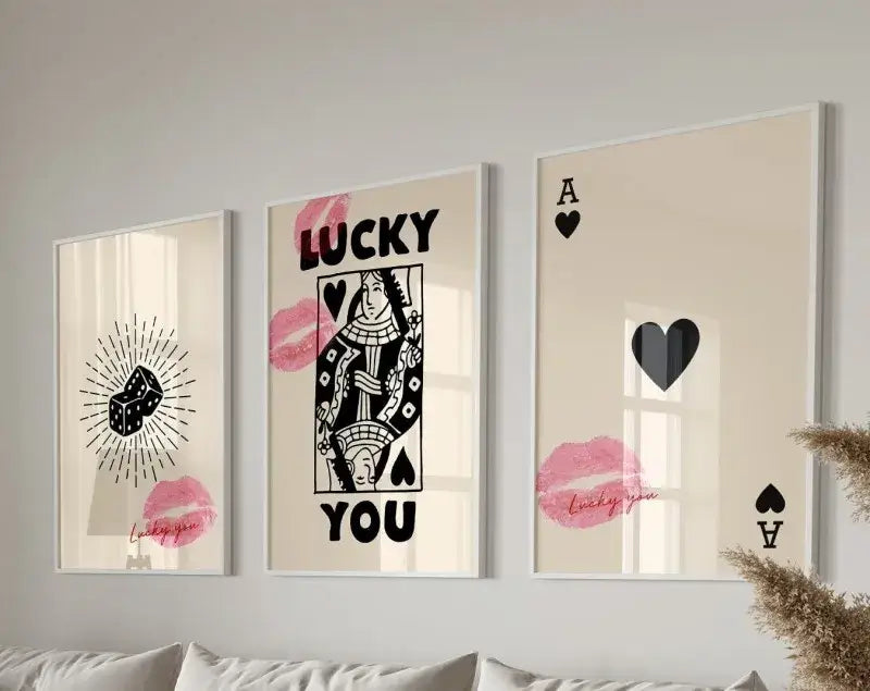 Three framed wall art posters with black and pink queen of hearts poker-themed designs on a cream background