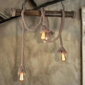 DecorBites™ beige rustic rope pendant light with three exposed Edison bulbs hanging from wooden beam for island use