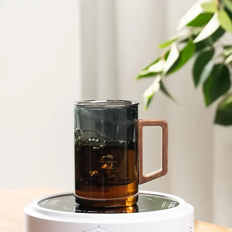 Sleek dark gray double walled glass tea cup with wooden lid kitchen