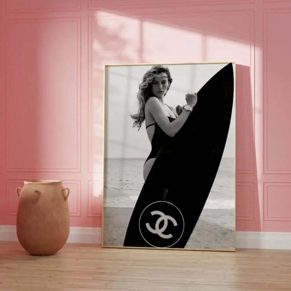 Black and white surfboard wall art featuring a woman with a chanel logo surfboard for teen room decor by decorbites