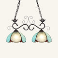 A pair of DecorBites™ stylish tiffany pendant lamps with black wrought iron and blue stained glass shades for dining room