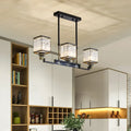 Black metal DecorBites crystal island chandelier with three rectangular glass shades and decorative scrollwork