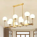 Modern gold-toned DecorBites opal glass island pendant light with 10 frosted globe lights for dining room