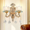 Traditional gold crystal wall sconce with e12 clear glass candle shades and dangling crystal teardrop pendants for restaurant lighting