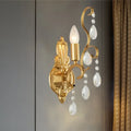 Traditional gold metal candle wall lamp with ornate design and dangling crystal teardrops for living room use