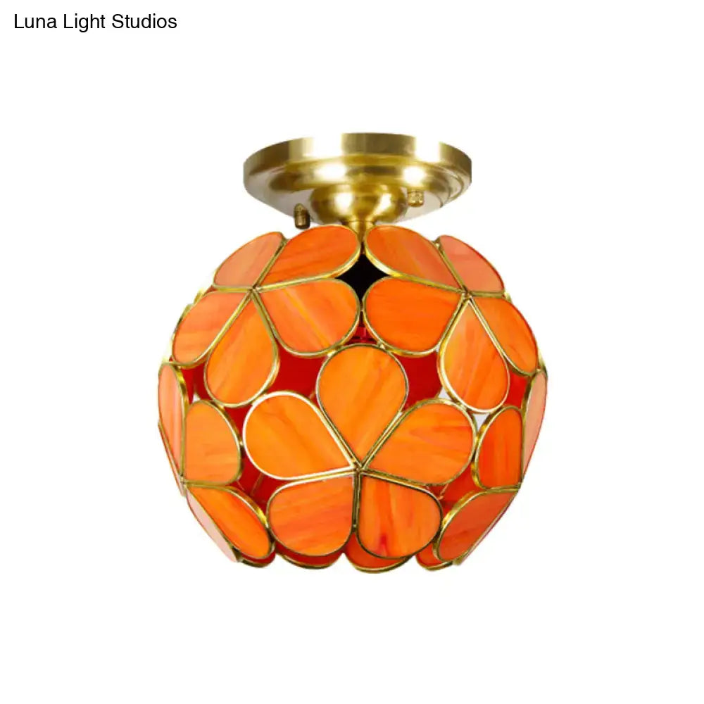 Vibrant orange stained glass flower ceiling light with brass fixture and petal-shaped panels by decorbites