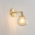 Vintage brass wall light with champagne clear ribbed glass shade and exposed filament bulb for bedroom use