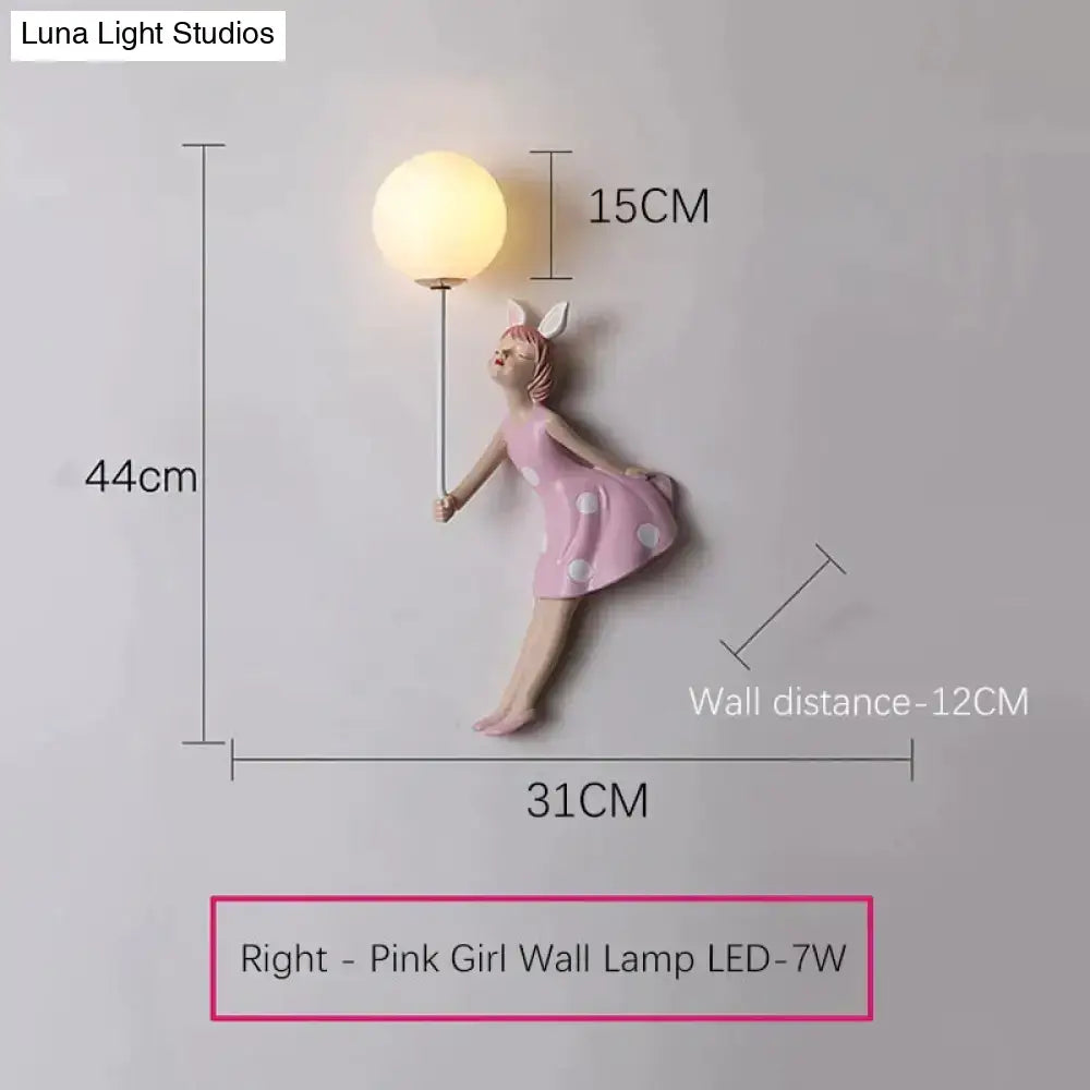 Whimsical pink girl wall lamp featuring a bunny figurine in a polka dot dress holding a glowing orb for bedroom use