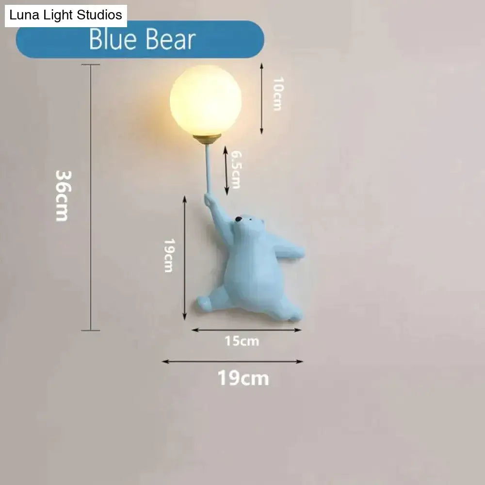 A light blue sculpted polar bear wall lamp with a warm bulb held aloft as a whimsical girl wall lamp for bedroom