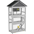 Gray wooden outdoor bird aviary by DecorBites with black roof and wire mesh panels featuring small mid-level door